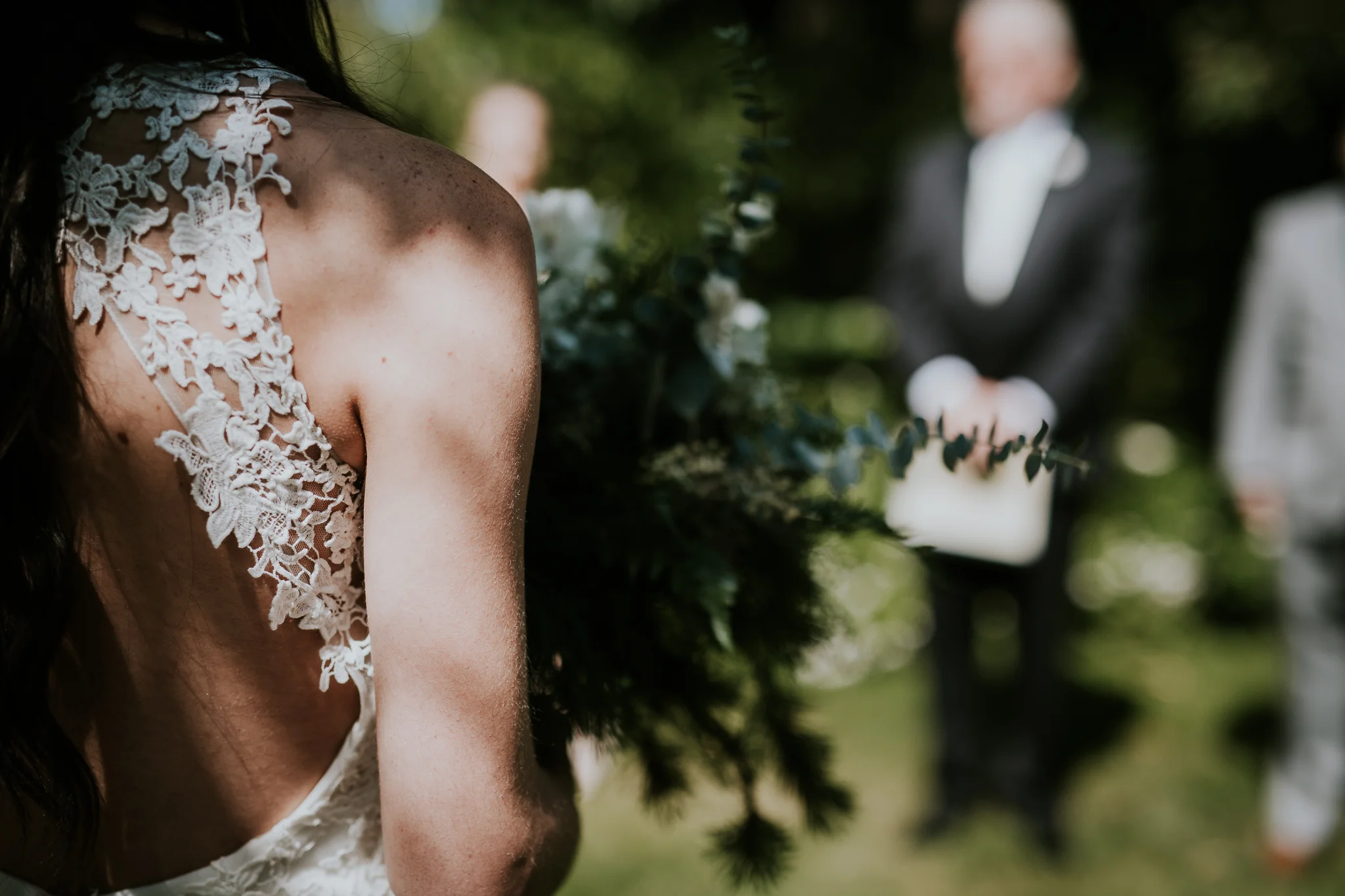 Close up of brides bouquet and back of bride as she walks down aisle at Starling Lane winery