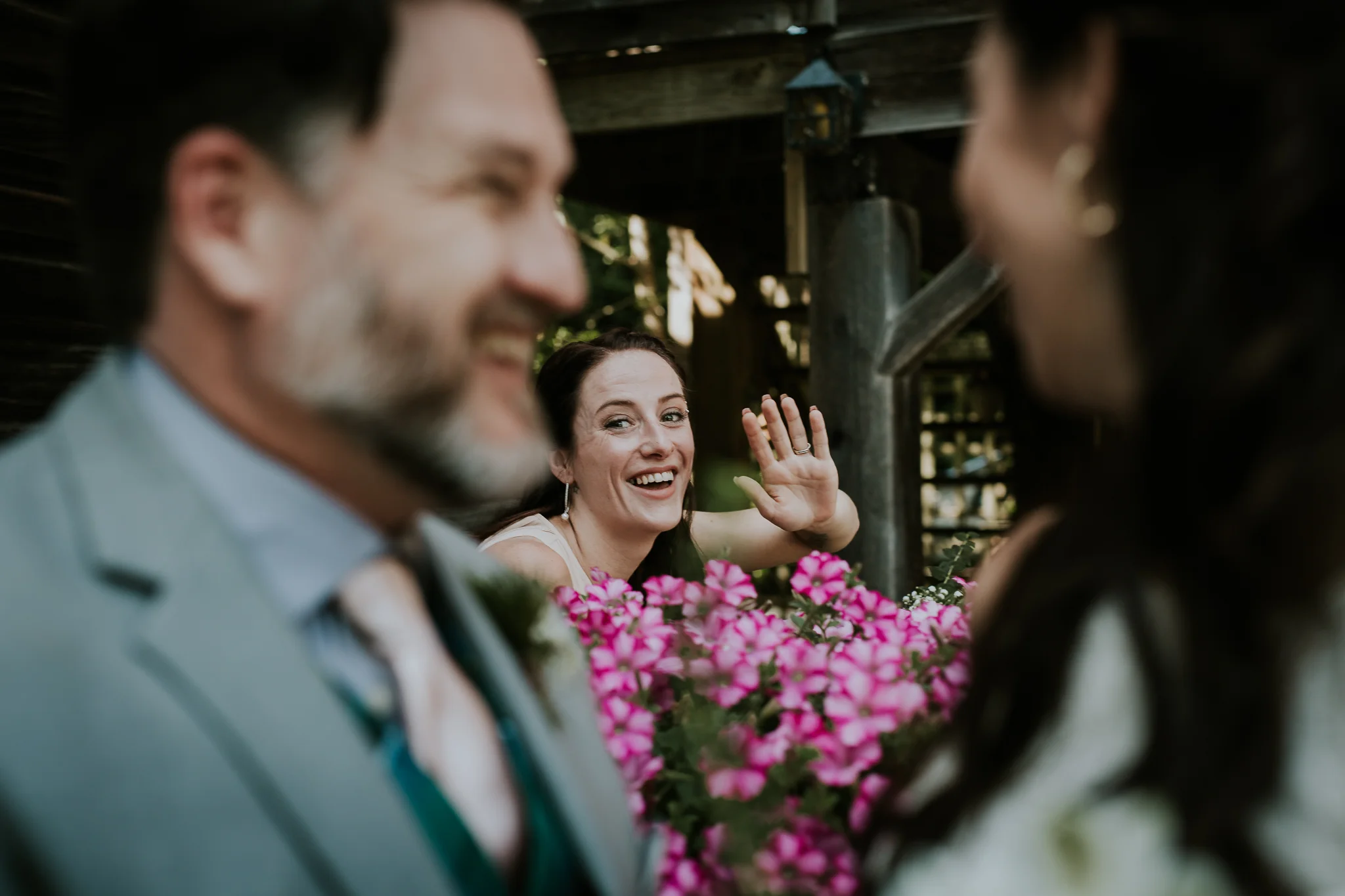 Bridesmaid looking on as bride and groom share a kiss after the ceremony in Victoria BC