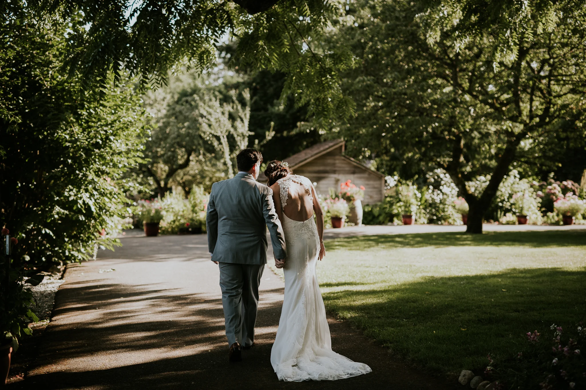 Bride and groom holding hands walking through vineyard wedding on Vancouver Island