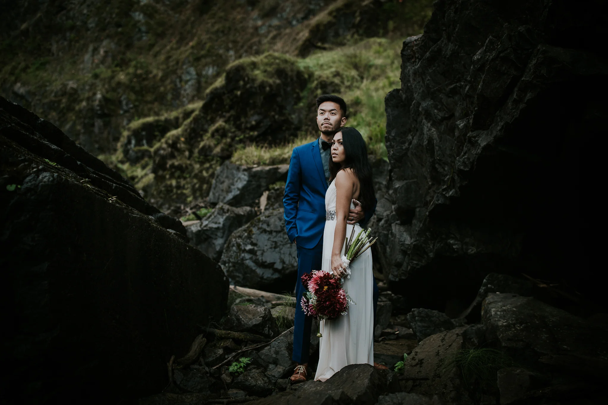 Bride and groom looking majestically out at Snoqualmie falls during elopement