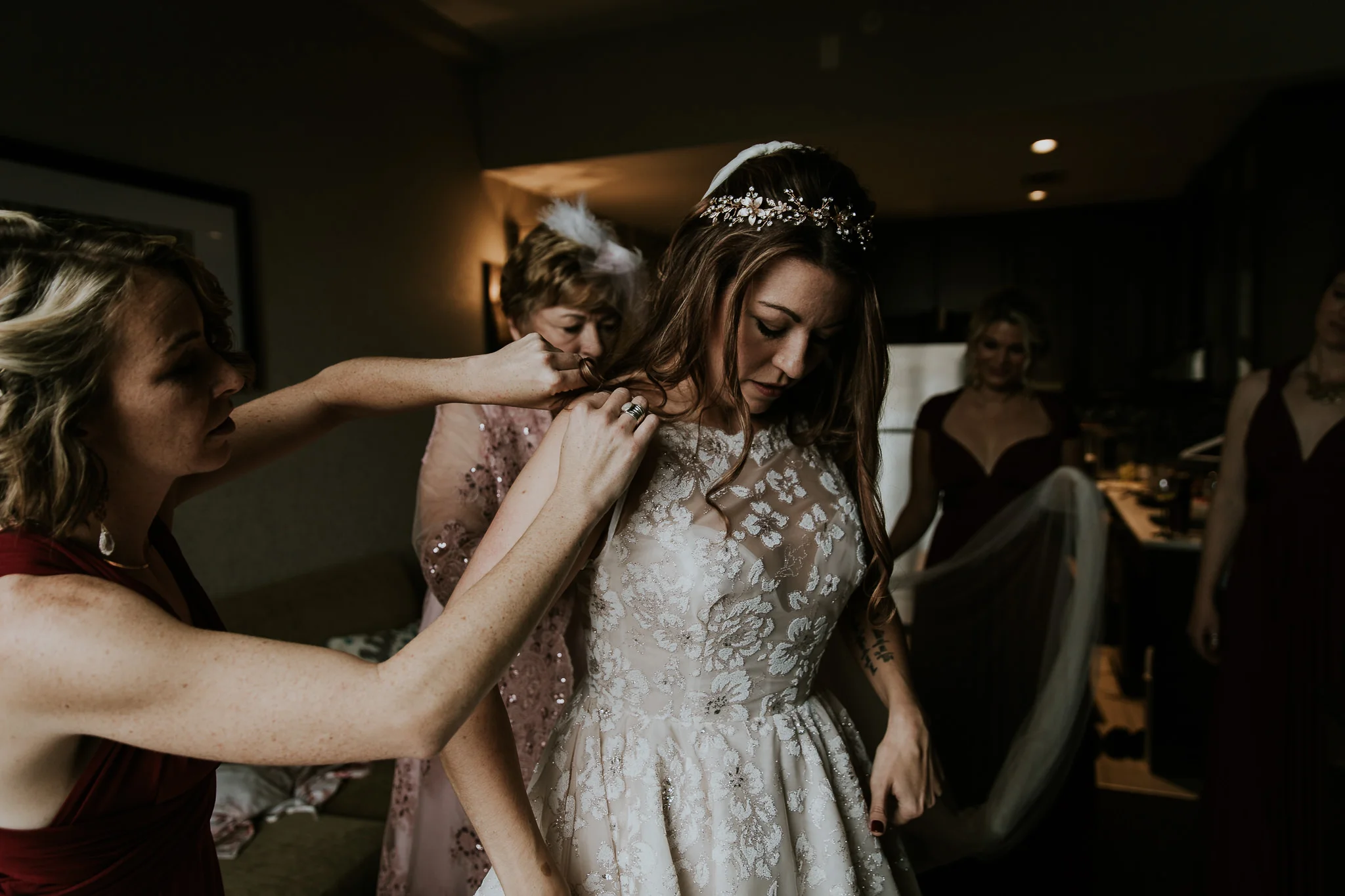  brides mom and bridesmaids help her get dressed during destination wedding  