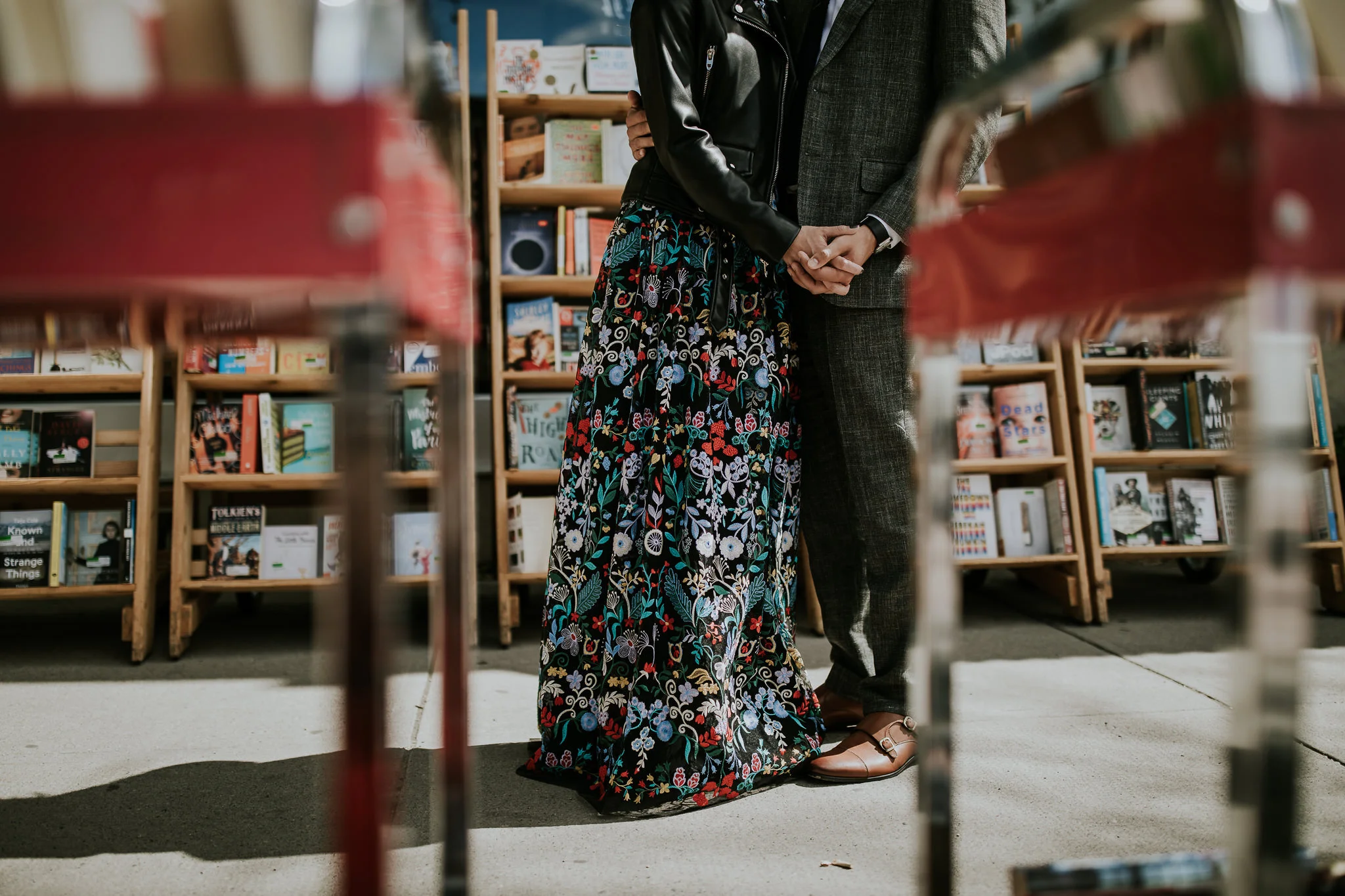 Bride and groom holding hands in urban wedding photos near bookstore downtown Calgary