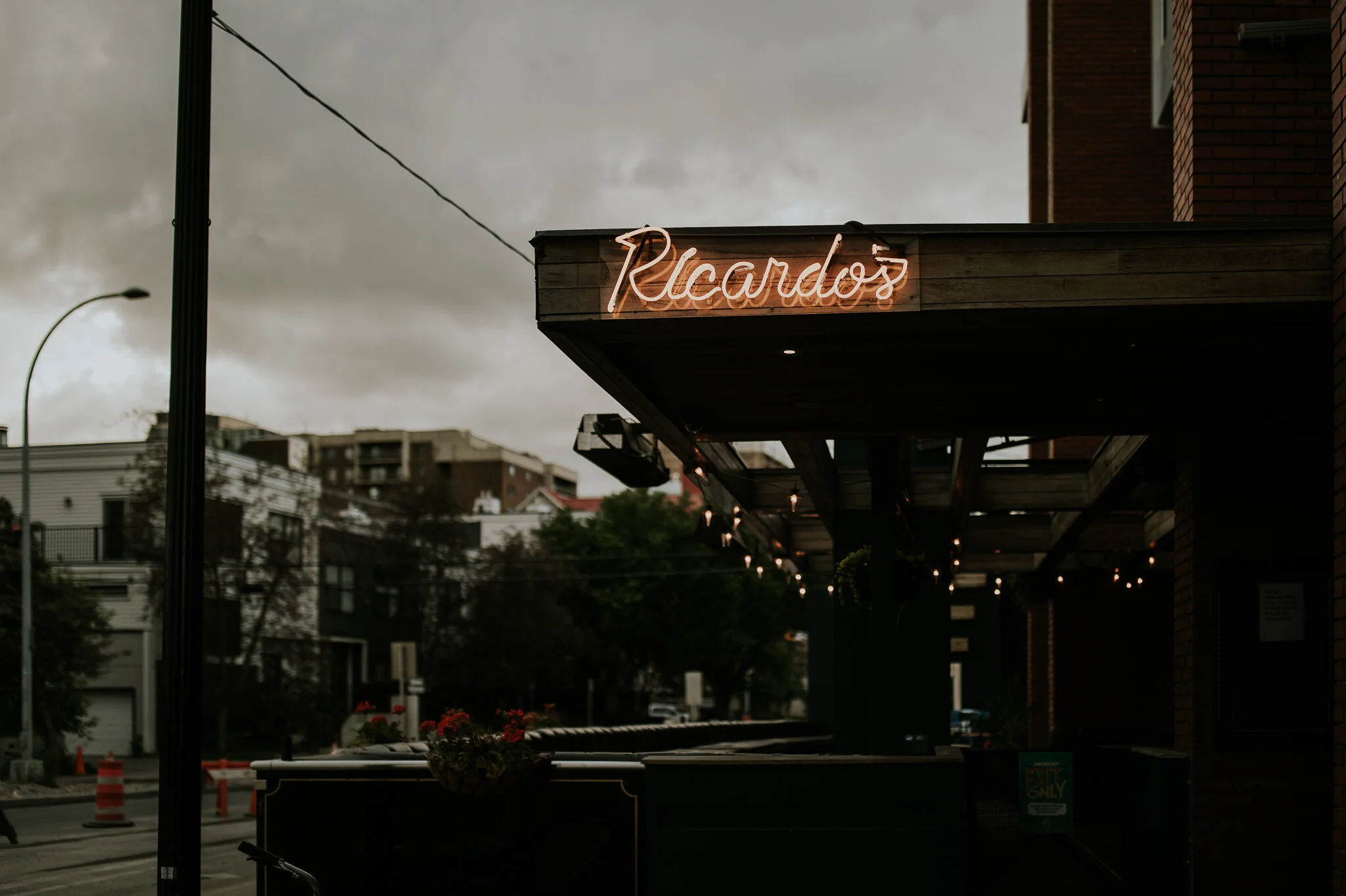 Ricardo’s Hideaway sign lit up for intimate wedding reception while storm clouds roll in.