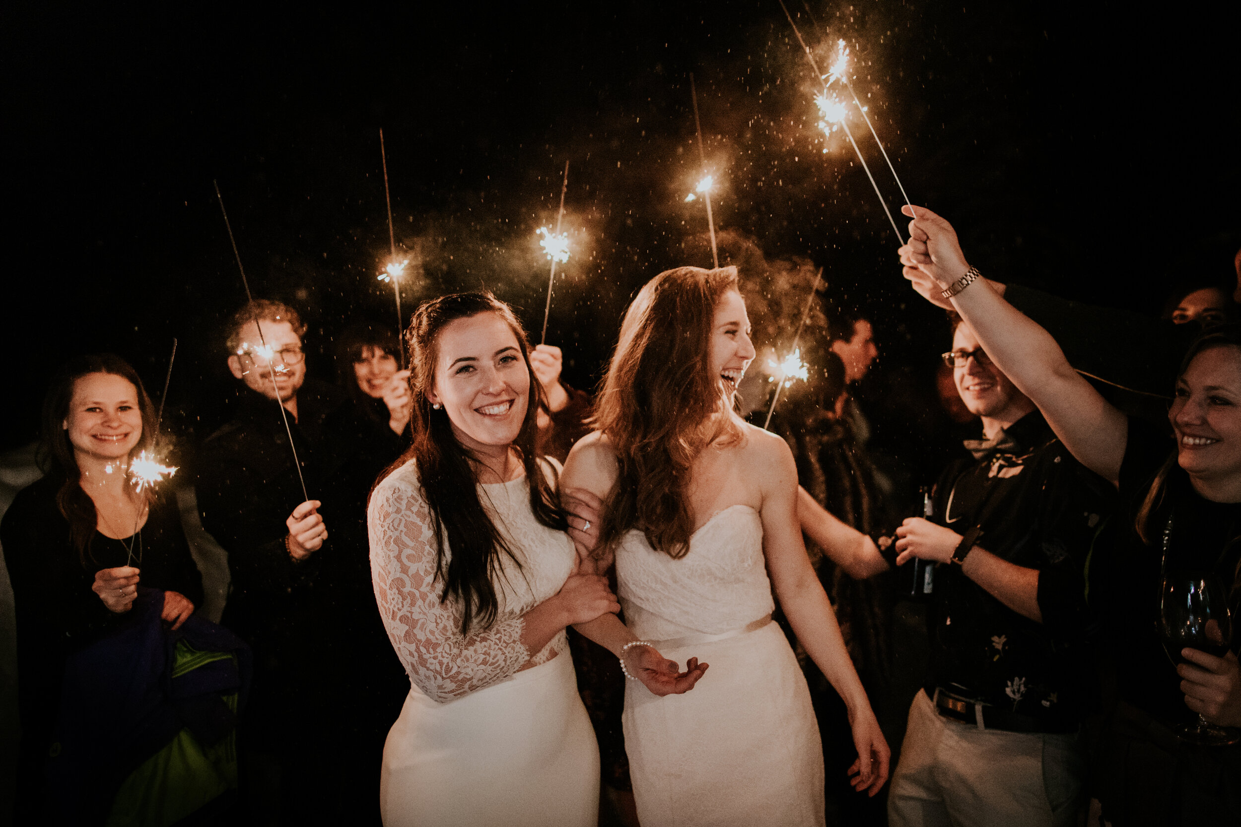  lgbtq couple leave during sparkler exit surrounded by friends during destination wedding  