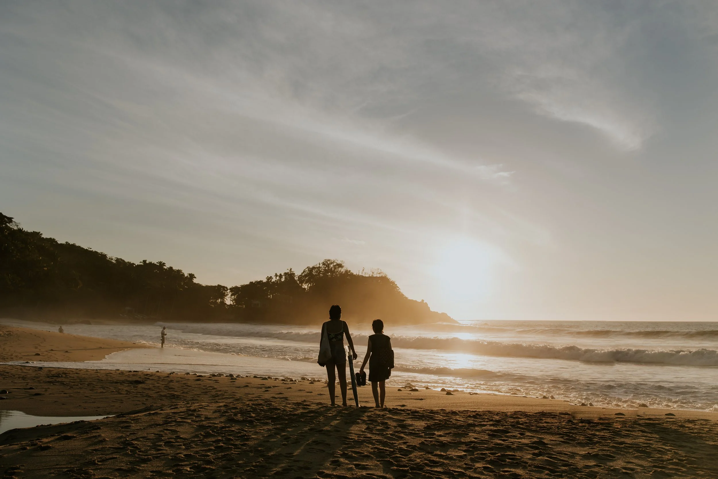  silhouette of two people standing in front on ocean during sunset at sayulita mexico destination  