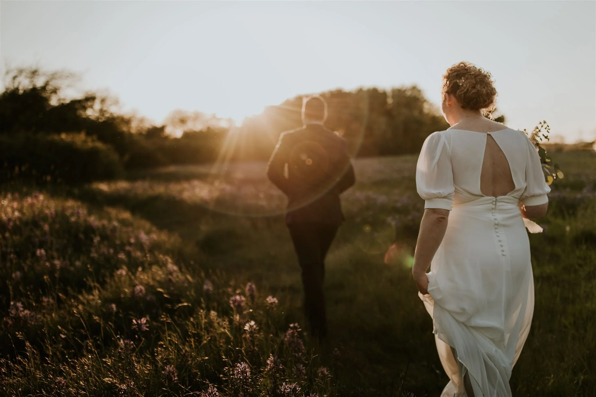  bride holding dress walking in golden sunset during destination wedding portraits in mexico 