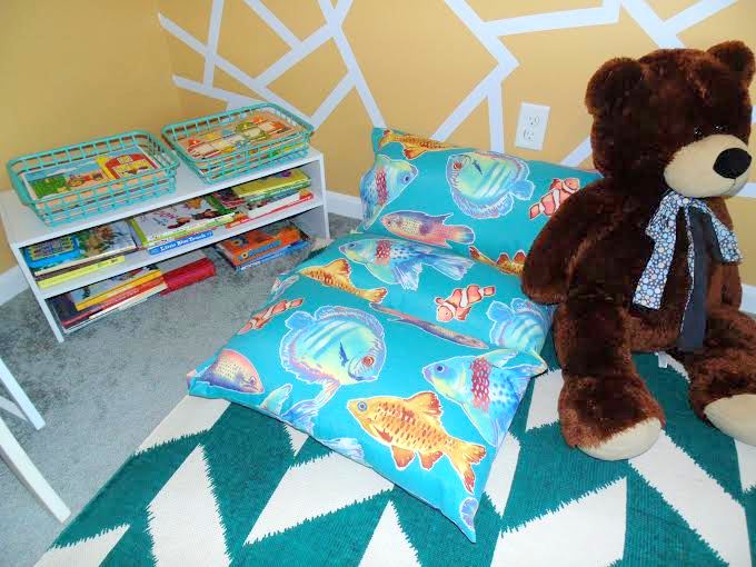 A custom floor pillow, made by Rylan's Nana, is perfectly cozy for curling up with books.