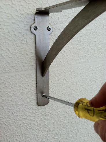 Once your toggle anchors are in, place the bracket over the anchors and screw the screws into the anchors.