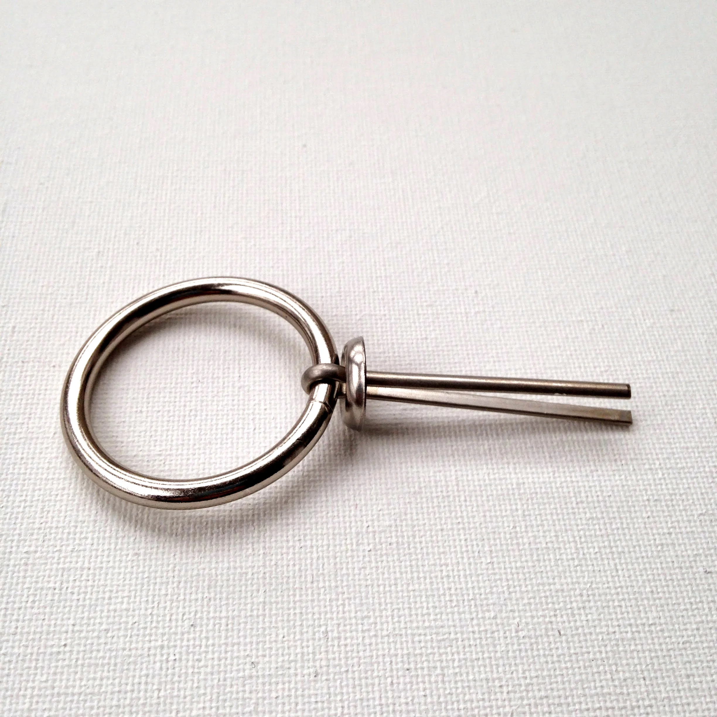 3. Once the ring is on, pinch the prongs of the cotter pin and slide on the finishing washer with the beveled side facing the ring.
