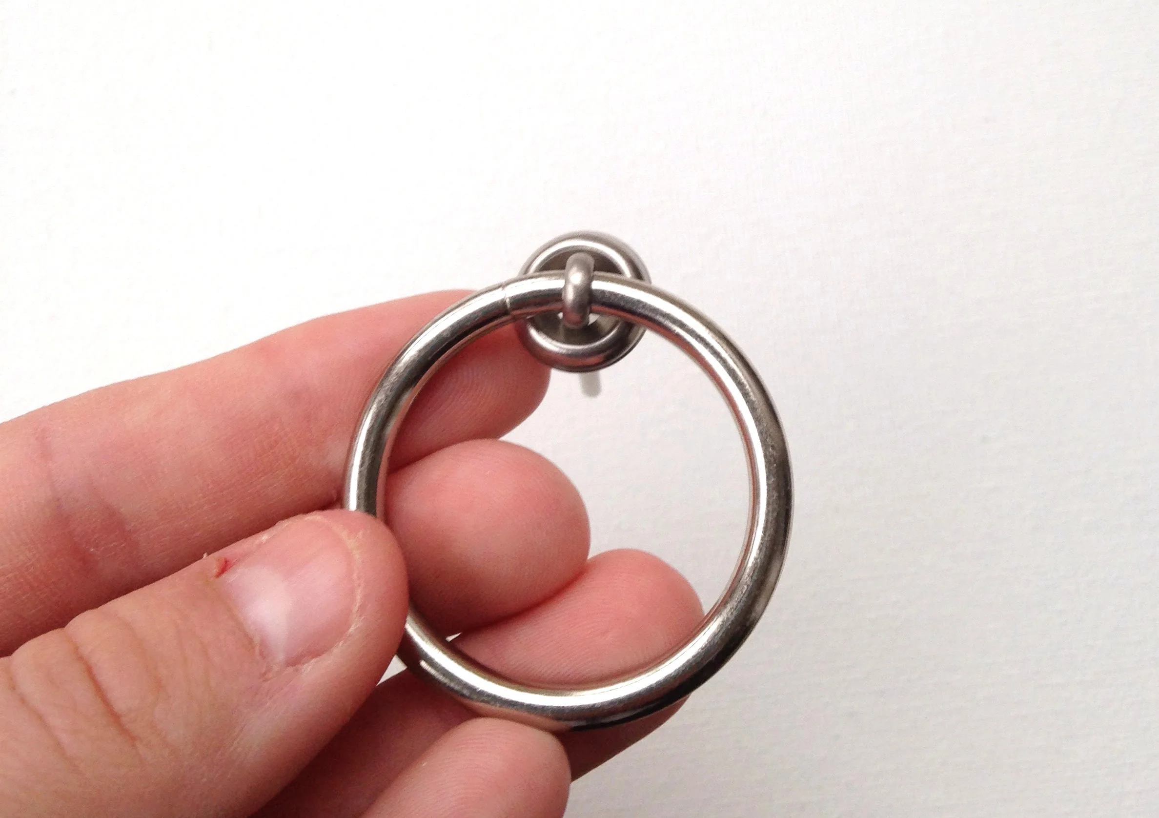 4. Now you've got the makings of the ring pull. To secure it onto the drawer, thread the prongs through the hole in the drawer and slide the regular washer on the inside of the drawer. Then bend the ends of the cotter pin like a brad to keep the pulls in place. 