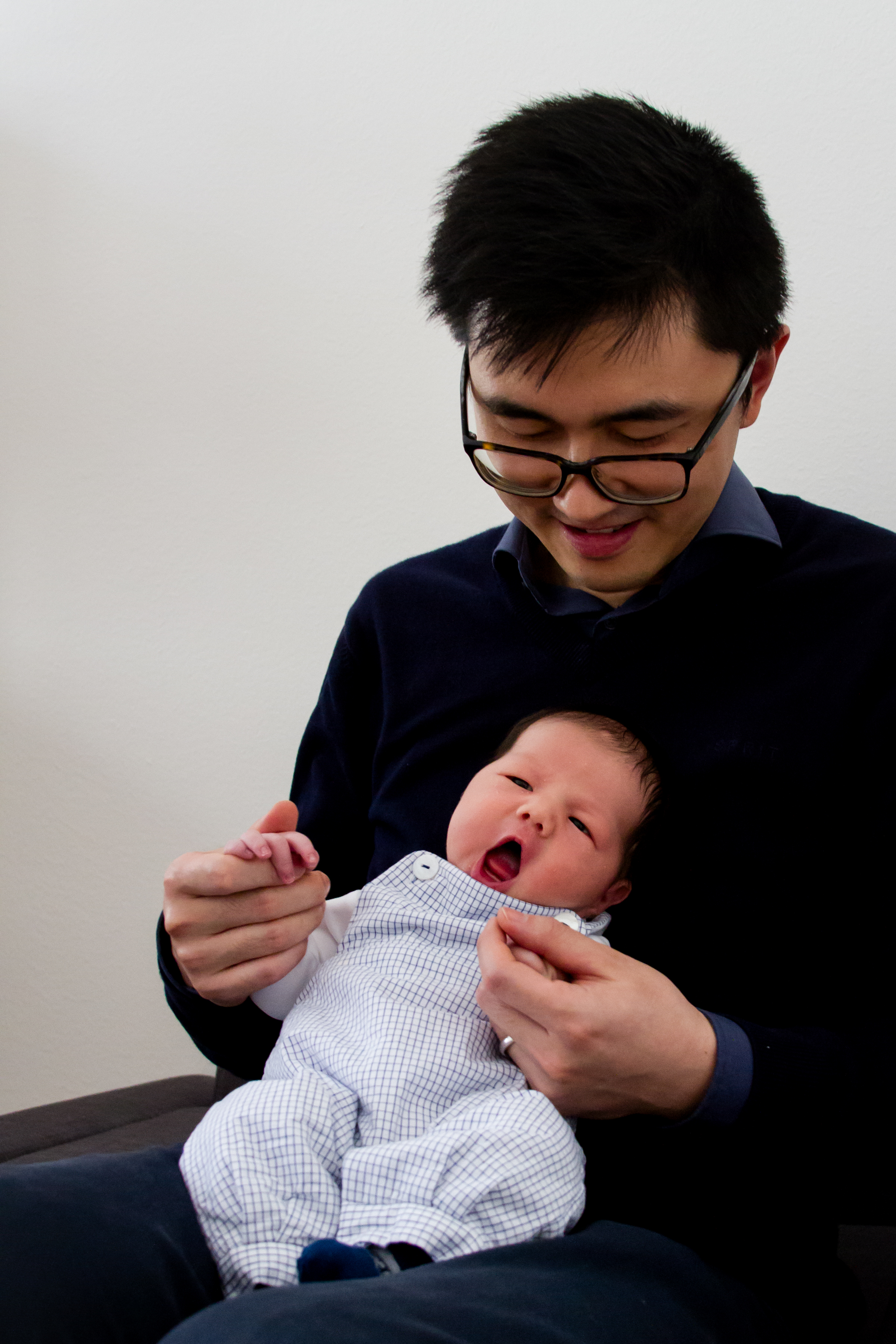 Dad plays with newborn son