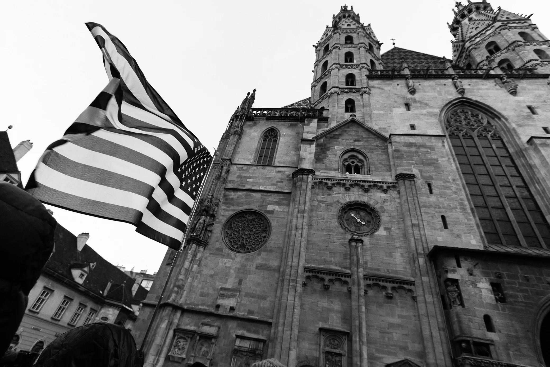 black and white photo featureing the american flag waving in front of Stephansdom in Vienna, Austria
