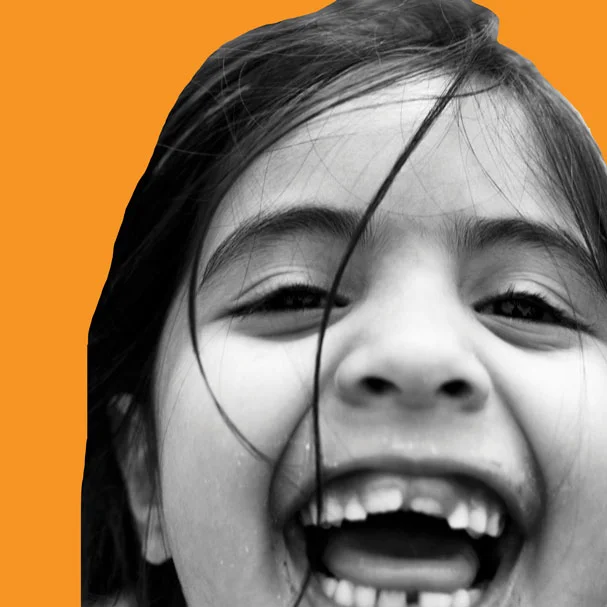 Girl-smiling-in-playground-square_orange-sm.jpg