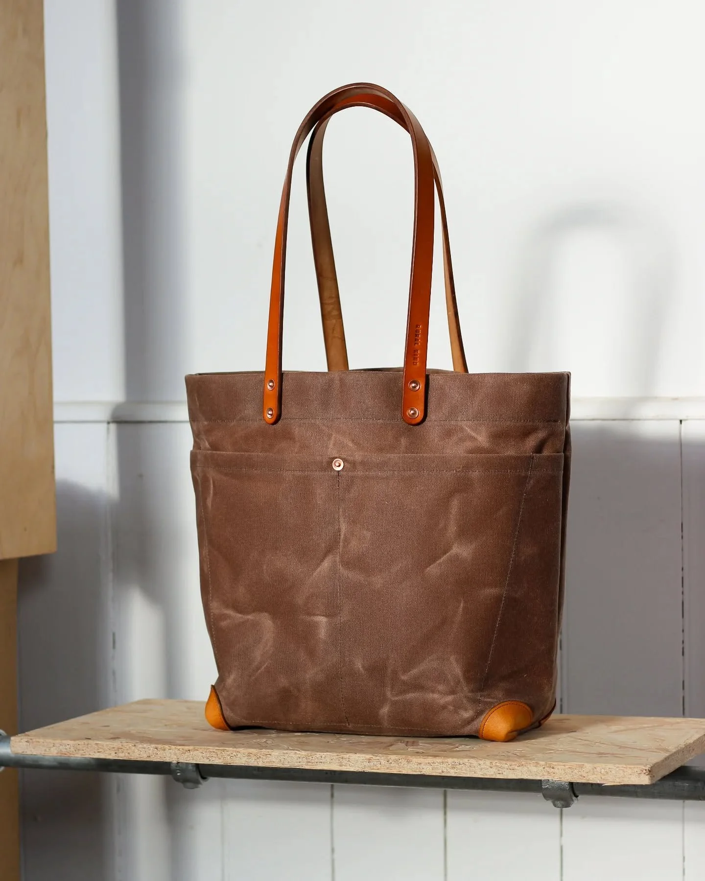 This rather handsome bag was an experiment. It's a variant of our regular Utility bag, swapping out the short carry handles for longer shoulder length ones and adding some leather corner protectors. There's absolutely nothing wrong with it except for