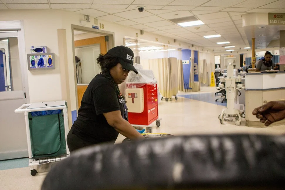 Ebony Copeland, 31, prepares the gurney with a new sheet for the next patient. The hospital often shares supplies like sheets, bags and oxygen tanks with the ambulance corps.