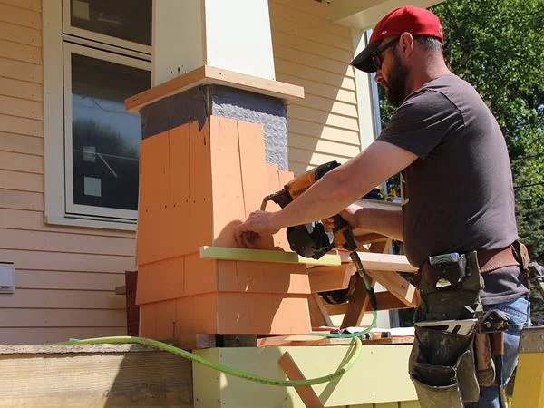 To help visually unify the home's front facade, the shingles on the porch post bases echo the shade of the shingles on the dormers above.