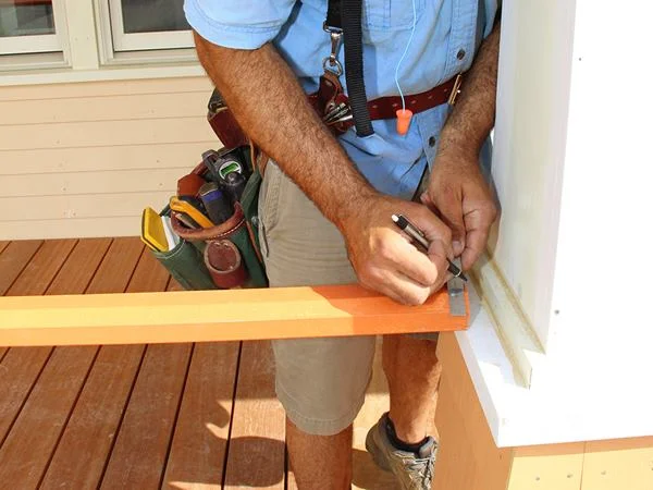 Pollard marks a railing end in place before cutting the piece to fit.