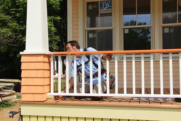 Pollard shims the lower rail and baluster assembly up tight against the already-positioned upper rail.