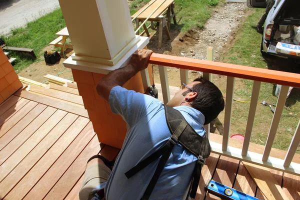 Screwing from below, Pollard fastens the railing assembly through the sub-top-rail into the upper railing using his pre-placed stainless steel #7 1.5-inch screws.