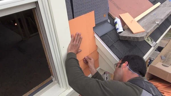 Pollard aligns the shingle butt to his level layout line.