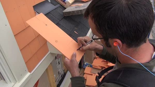 Pollard darkens his scribed line so as to be able to see clearly as he cuts the line with a jigsaw.