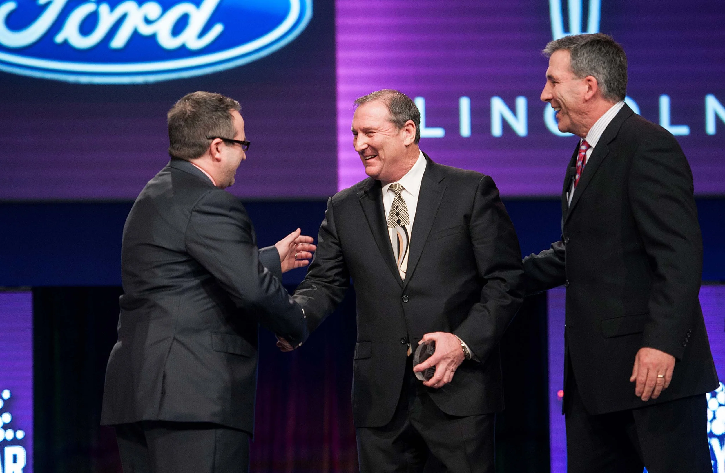 Shaking hands at a conference awards ceremony by Adrienne Battistella