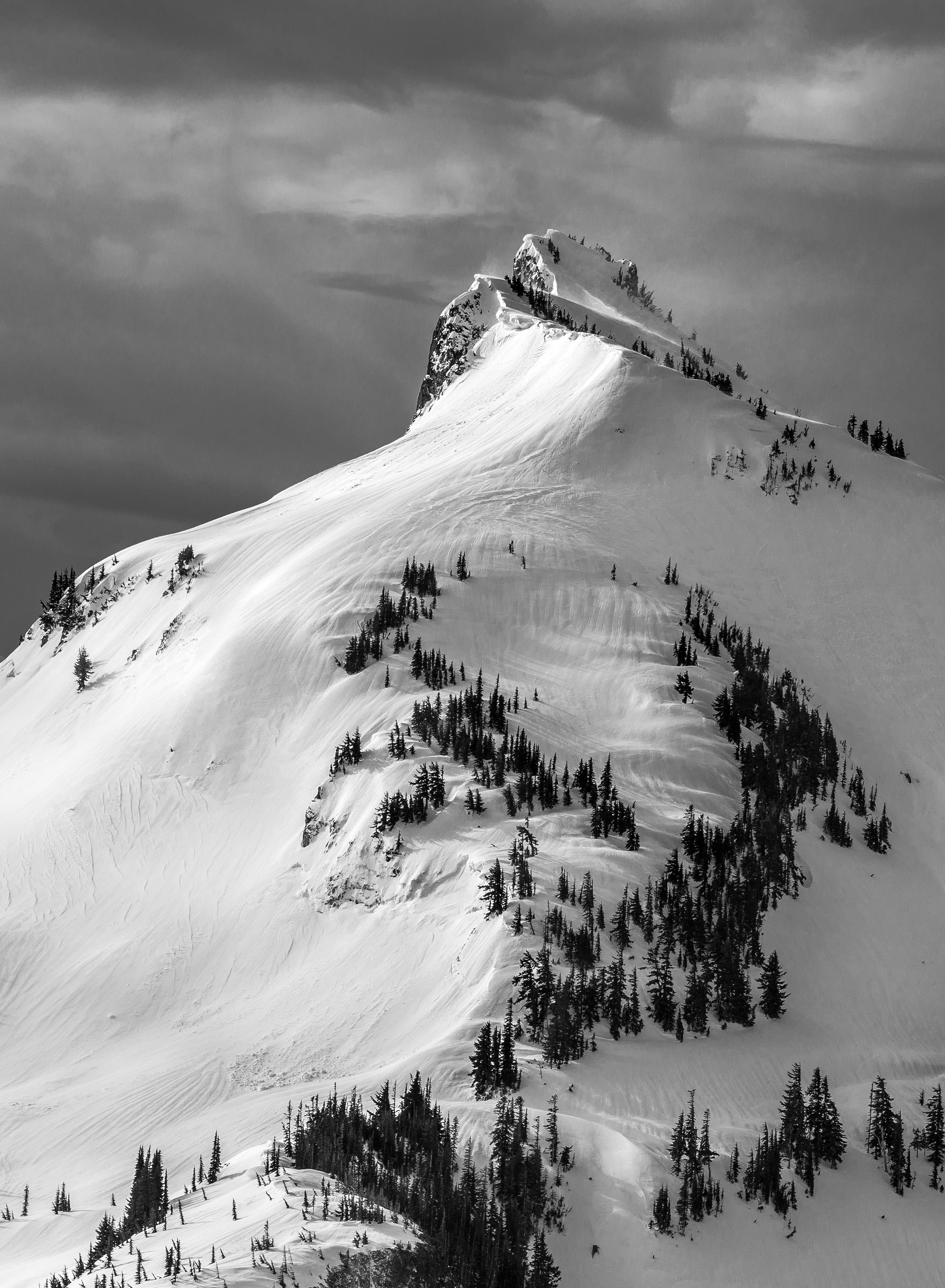 High winds blow snow up over the top of Manatee Mountain in the Tatoosh Range, Mount Rainier National Park, WA