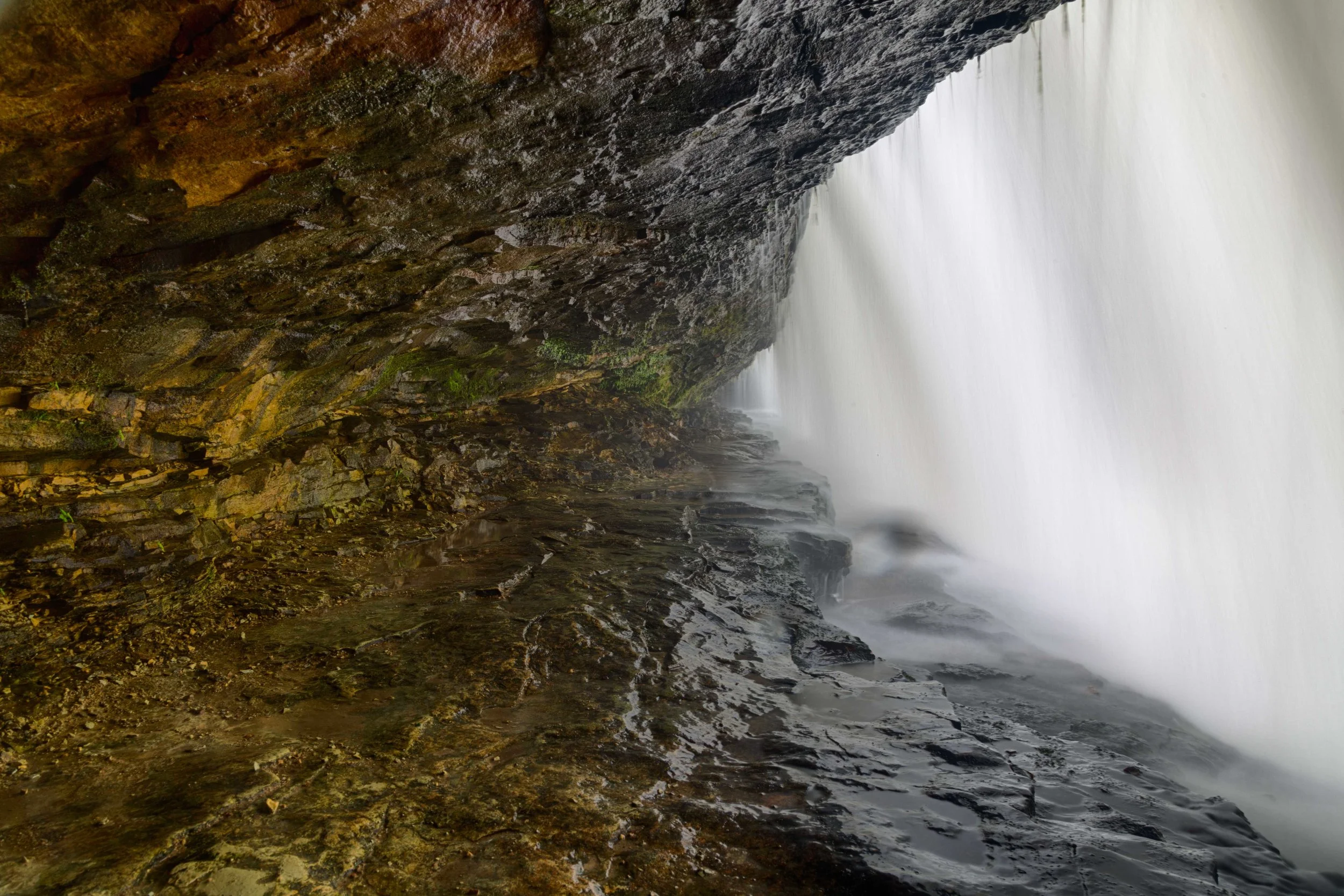 Crouched down behind the waterfall