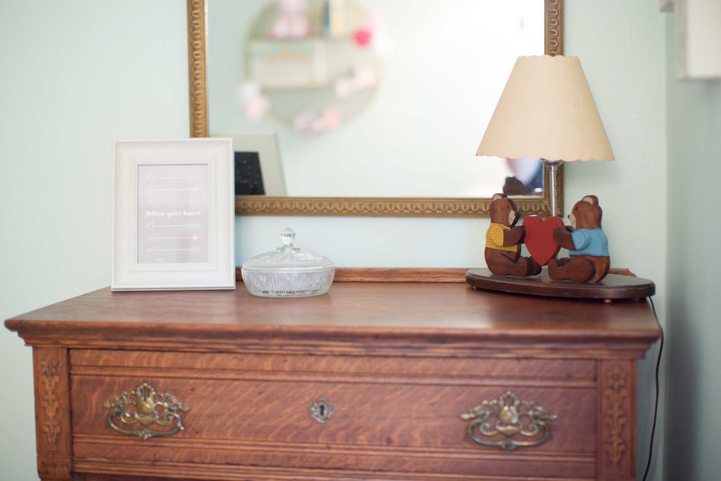 Her dresser belonged to Cal's other grandpa. When we moved into our home, Cal's mom offered it to us. It was in our guest bedroom, but as soon as I knew we were expecting, I moved it down the hall. The gold mirror, that you've seen here , belonged to my great-grandparents. I found it in Granny's attic.