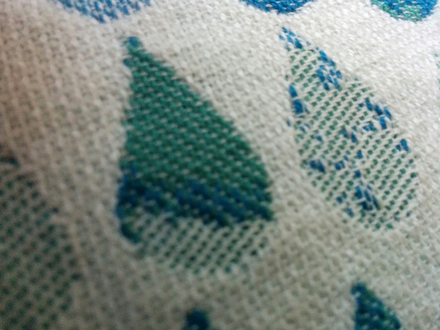 The droplet in the centre of this photo begins as green with slight additions of white, which transitions to add blue in equal parts to the green, and ends by being equal parts of white and green. The drop on the right of the photo is mostly equal parts white and green, with select blue threads peeking through in assorted lengths (yes, that is on purpose and not errors in the weave). Please excuse any blurriness in this photo. It was difficult for my amateur camera to stay focused on such an extreme close-up.