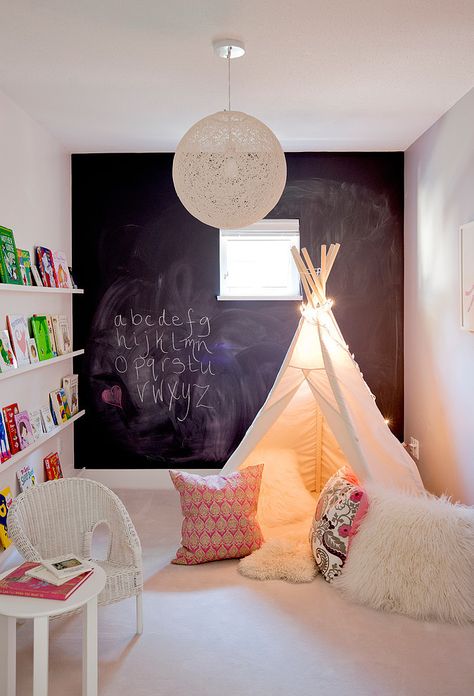 Make a decorative wall which at the same time is a creative corner, like this black board where they can draw new things all day long. The black boards ou can buy ready made or do it yourself by buying the special paint in stores. Create also a cozy corner for reading like this little Tipi, all children loves caves and small hiding places.