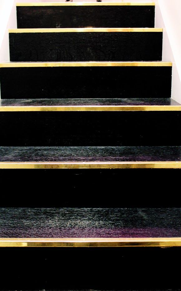 Staircase in black lacquer finished with gold metal strip. A very exclusive look.