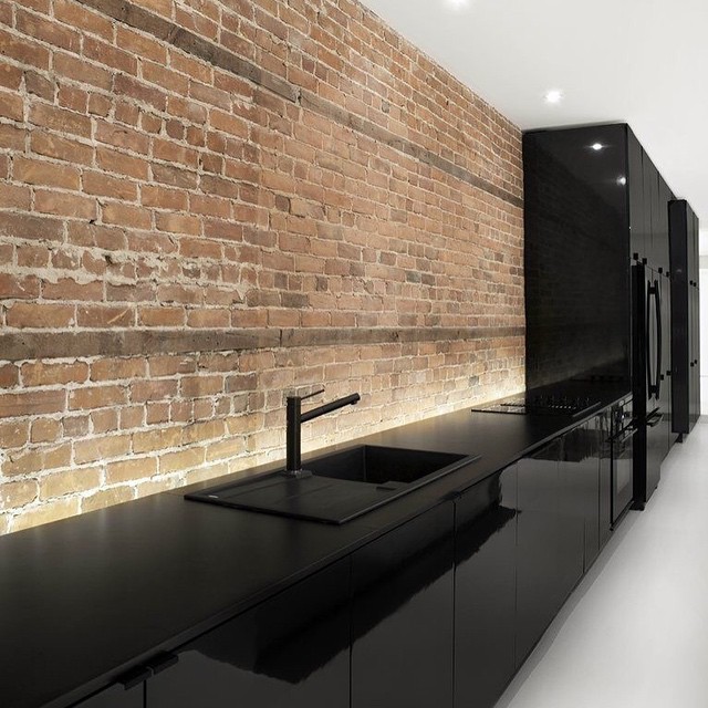 Amazing kitchen in black lacquer. Specially when mixed with raw stone. Great contrast.