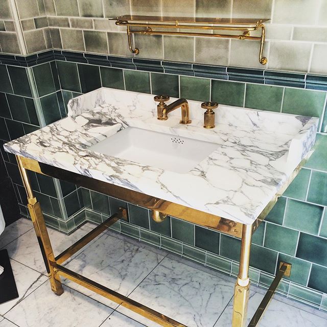 Very chick and elegant with a mix of tiles, marble and brass.
