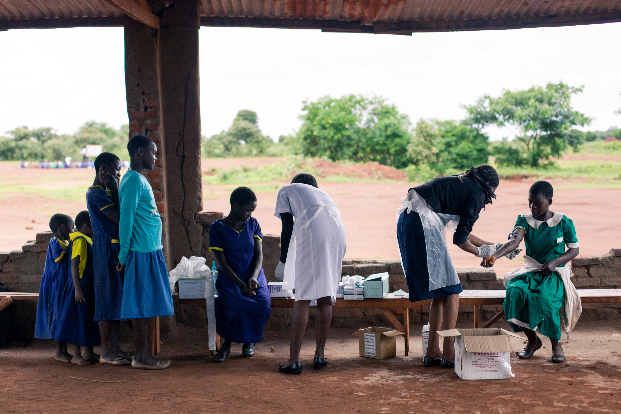 Phlebotomists Hawa and Lydia draw blood samples from students who had volunteered for the appraisal.