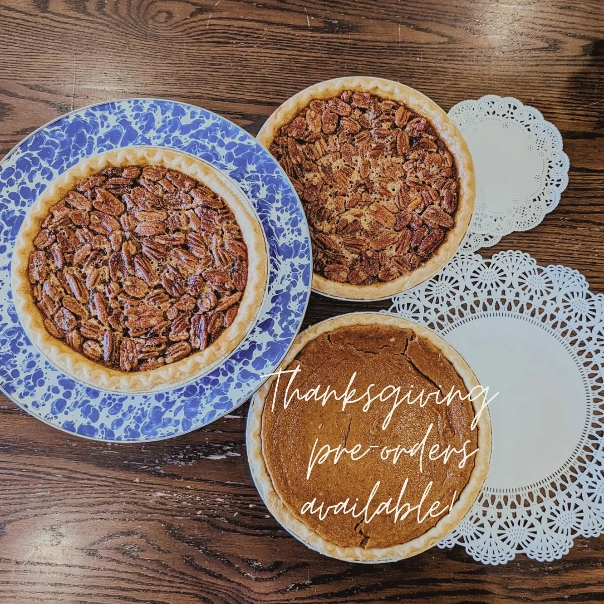 Photo of pecan, pumpkin pies on a wood table