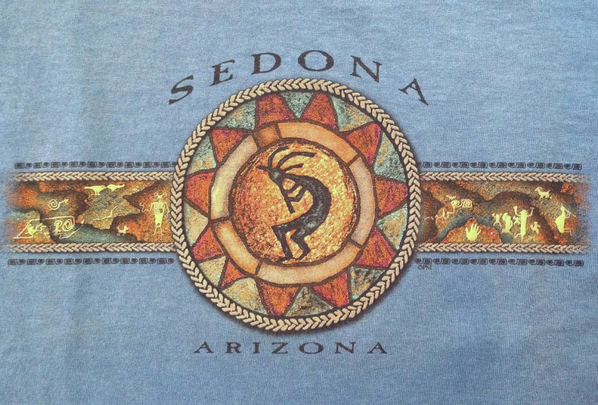 Kokopelli is a Native American petroglyph design found in Sedona and Arizona. Cotton t-shirt available in Rust and Blue.