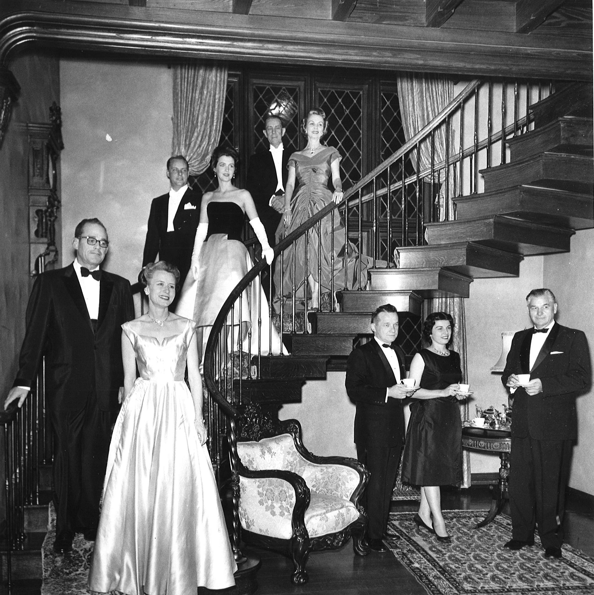 Sybil Harrington at one of her balls (Pictured in Green Dior dress, highest on staircase)