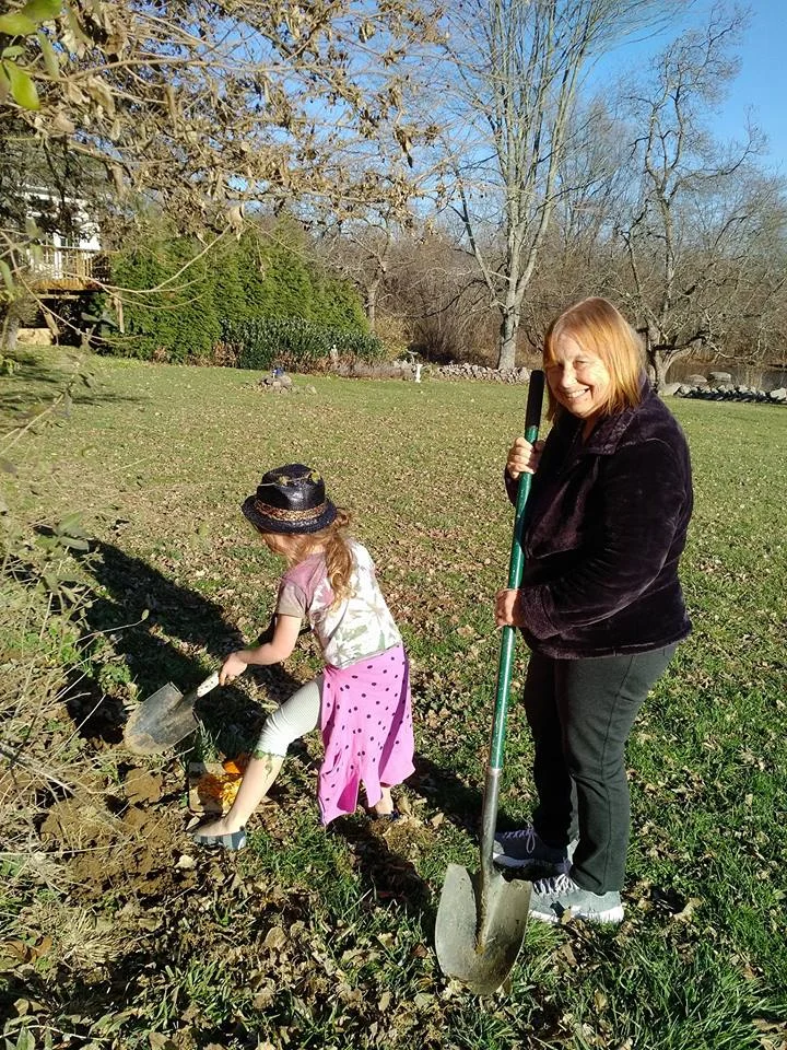Florence planting pumpkin seeds in the vegetable garden with her granddaughter Alice.