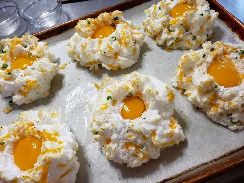 After whites have set, pull them out and drop yolks into indentations.
