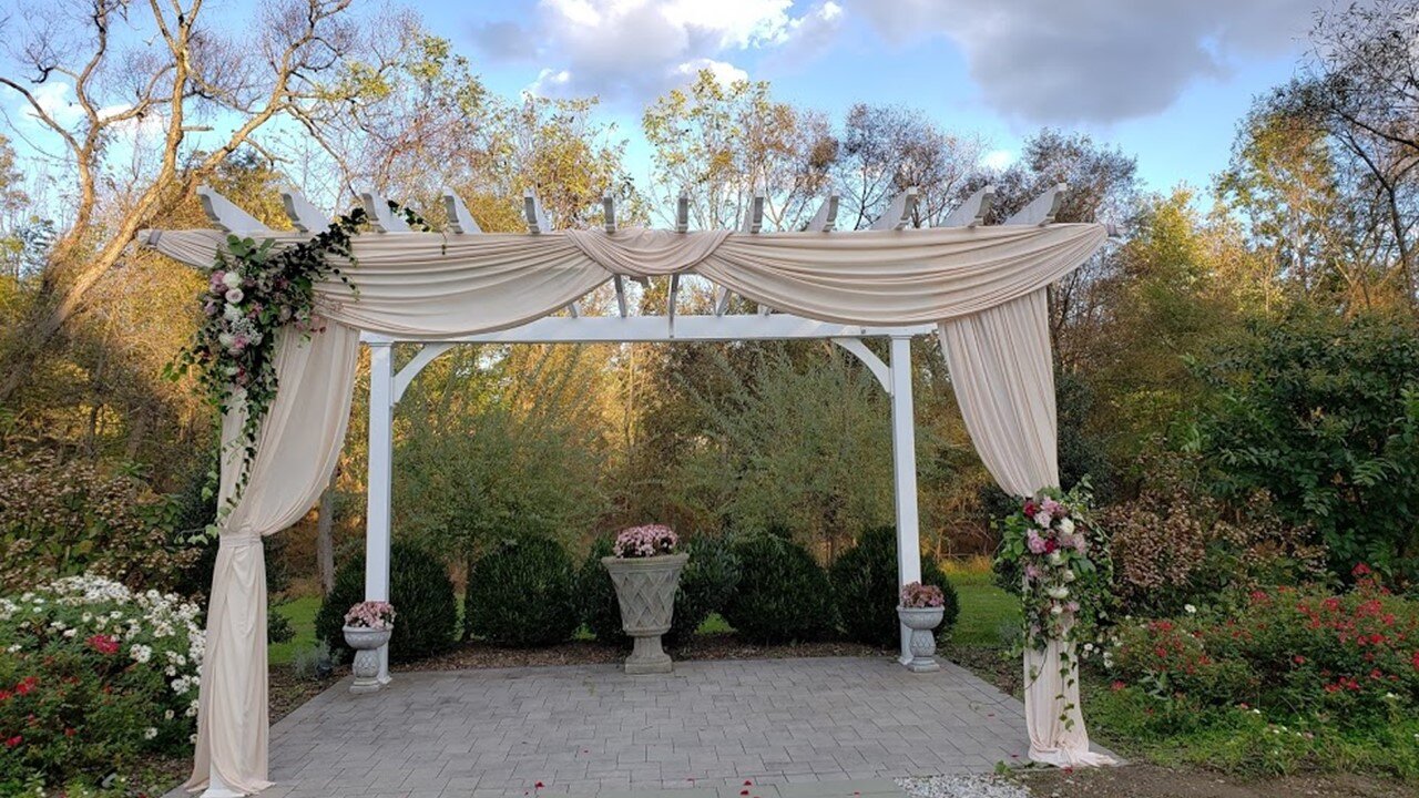 Pergola with Flowers and Draping by Sage Gardenworks