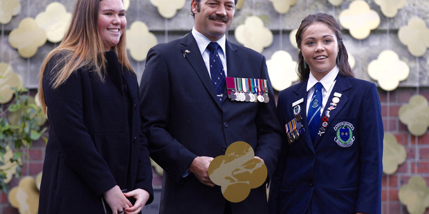 Students Graeson Papuni-Mclellan (L) and Caitlin Papuni-Mclellan (R) gather beside Corporal Willie Apiata (C), for a special ANZAC memorial service evening. Photo / Nick Reed