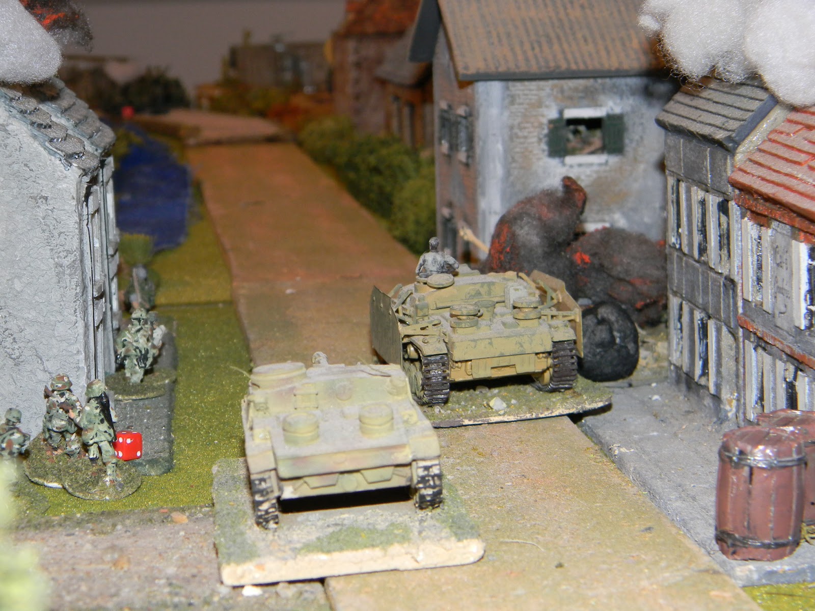 Meanwhile, two STuGs emerge onto the road in the village and engage the British carriers which had just appeared in the distance.
