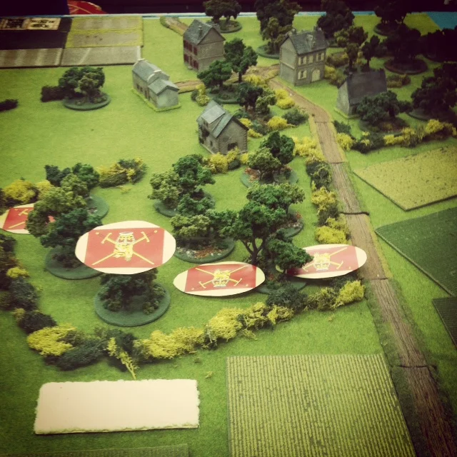 British infantry advance under Blinds through an orchard north of Caen