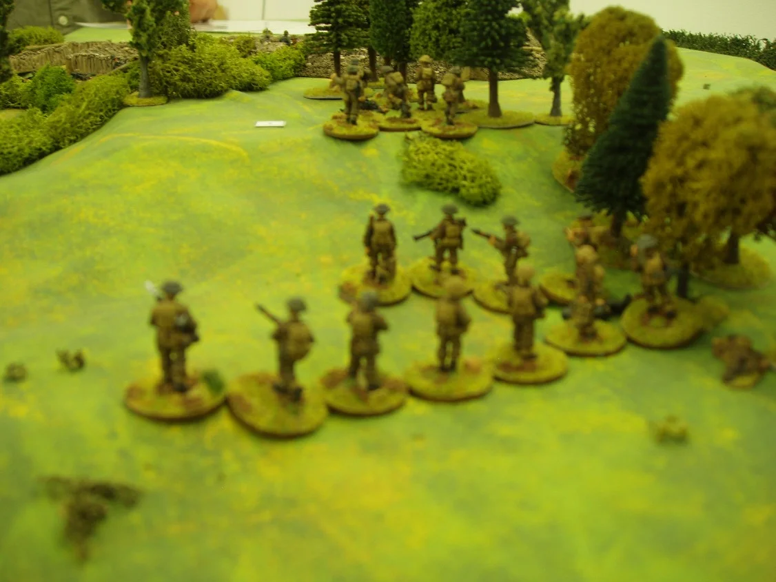 The platoon commander takes the reserve section in and the German squad runs for the trenches. The company commander reorganises the other sections and takes them back up the hill, ignoring off table MG fire from WN40b to the North.