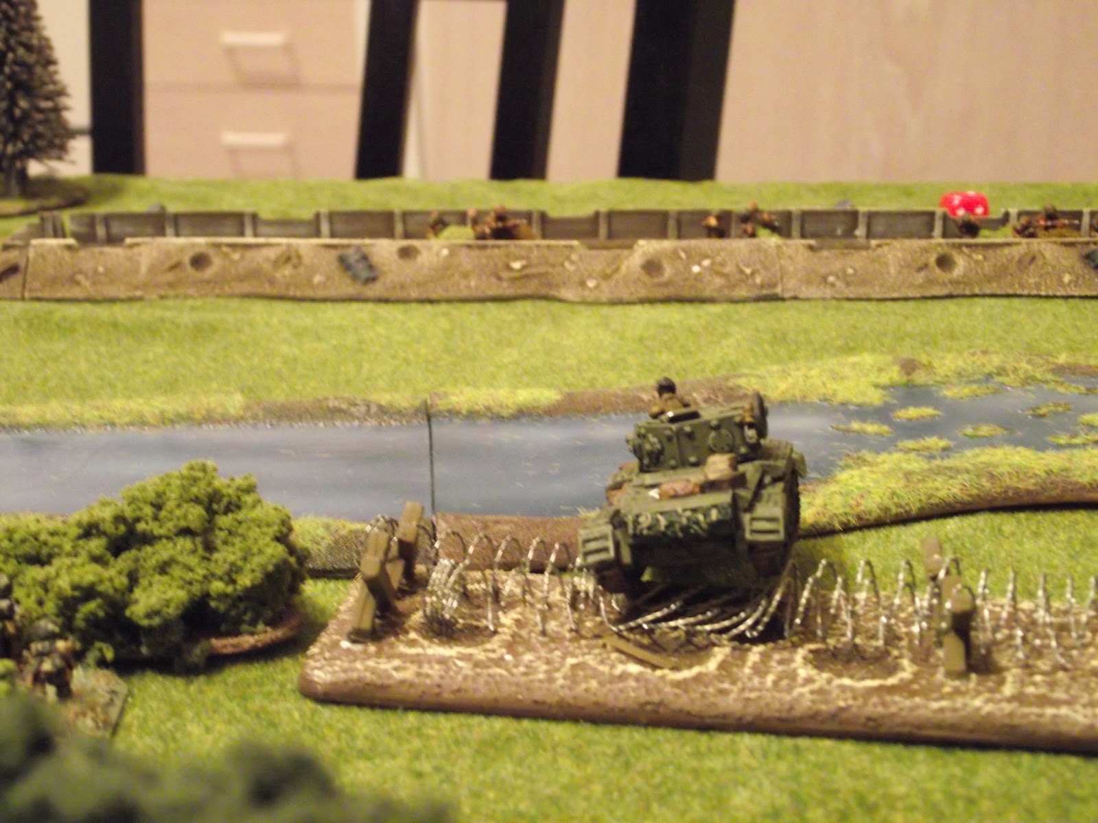  British Cromwell starts crossing the barbed wire whilst laying HE fire on the trench. 