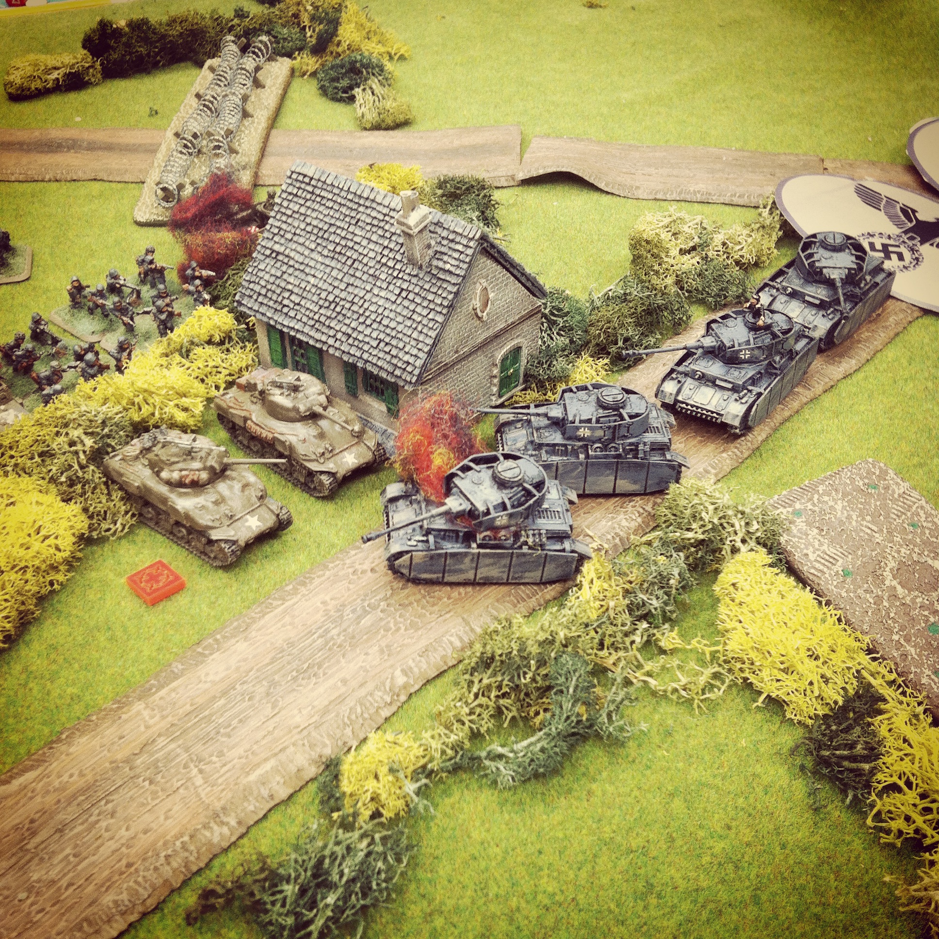 The lead German Panzer IV is destroyed, blocking the road