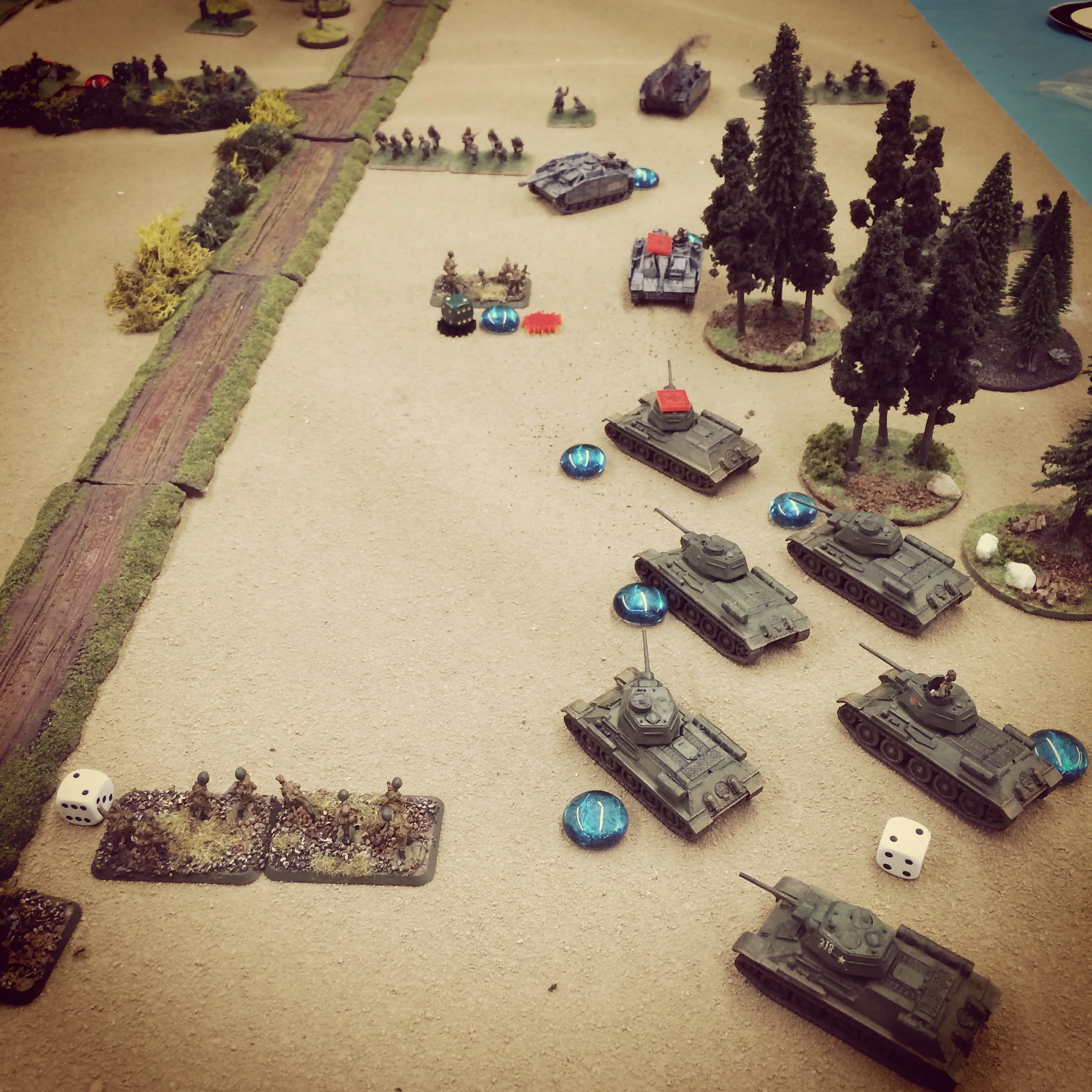 T-34s and StuGs duel at the edge of the forest as infantry begins to take heavy casualties on both sides