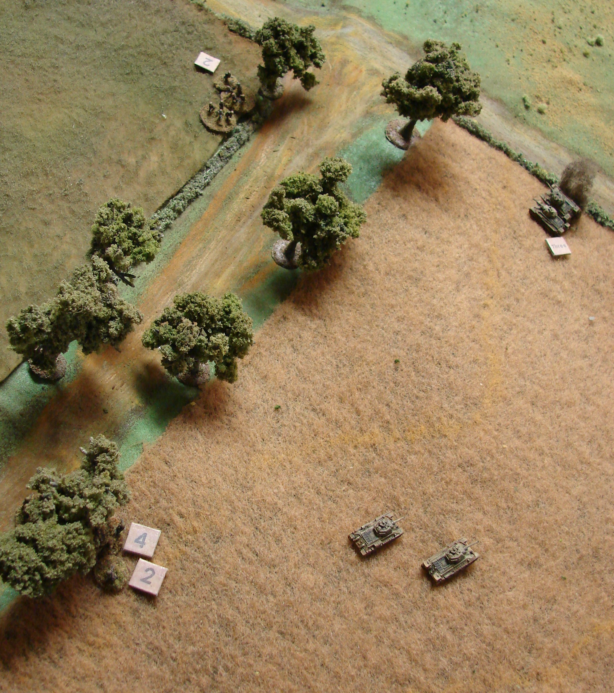 Stalled out on the Left One of the Soviet Big Men tries to rally the troops on the left while under fire from the grenadiers. The two T-34s are trading long range shots with a StuG, causing its engine to catch fire.