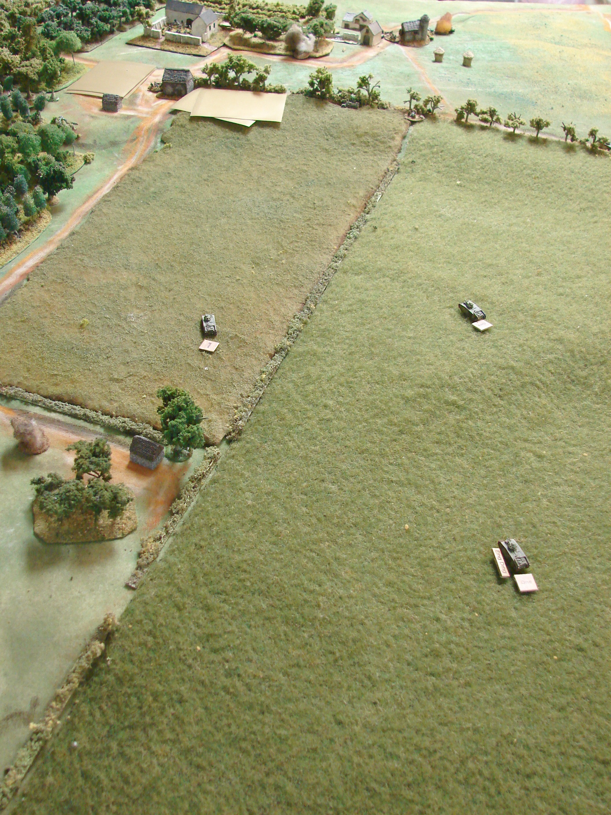 Chars continue As the Char b's move towards the farm, the infantry gun takes a shot at the flank of the lead tank. This causes a temporary immobilisation. The other tanks move towards the offending gun. Note that one of the other StuGs is now smoking after being hit by the Char CO's tank.